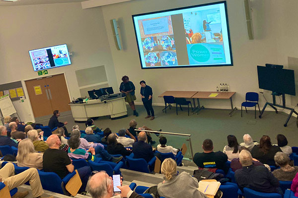 Shot from the back of the lecture theatre of a presentation