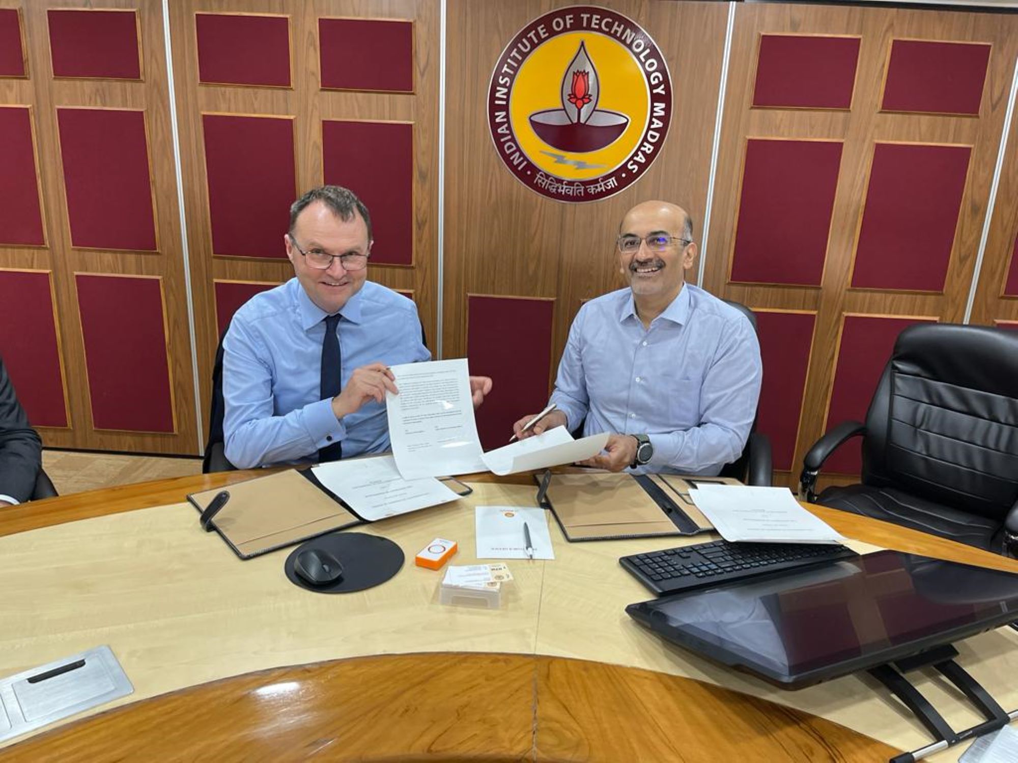 Adam Tickell and Koshy Varghese holding agreement document
