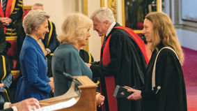 Academics dressed in robes meet Her Majesty The Queen inside Buckingham Palace