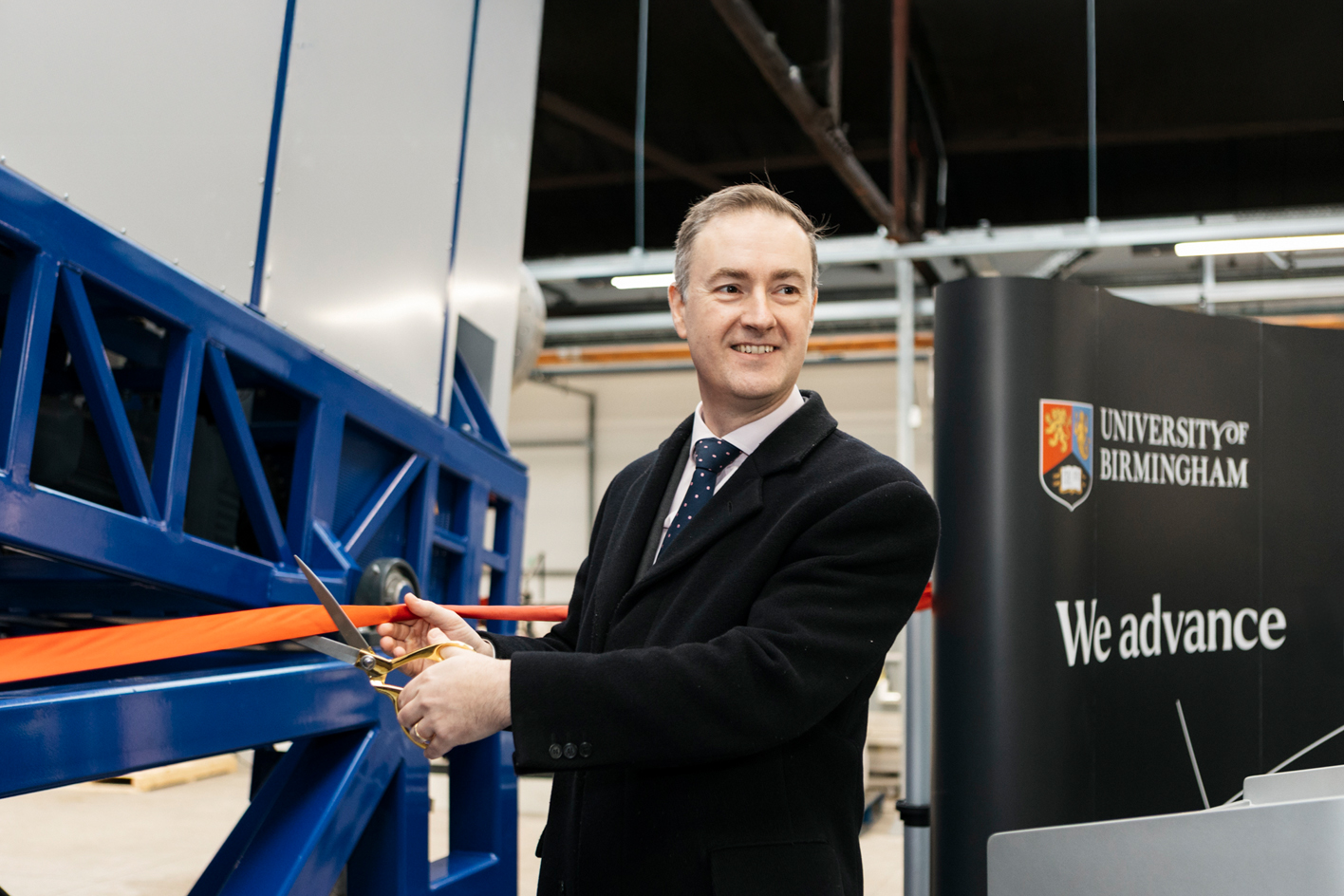 Chris McDonald MP cutting a ribbon at the official opening of the rare earth recycling plant
