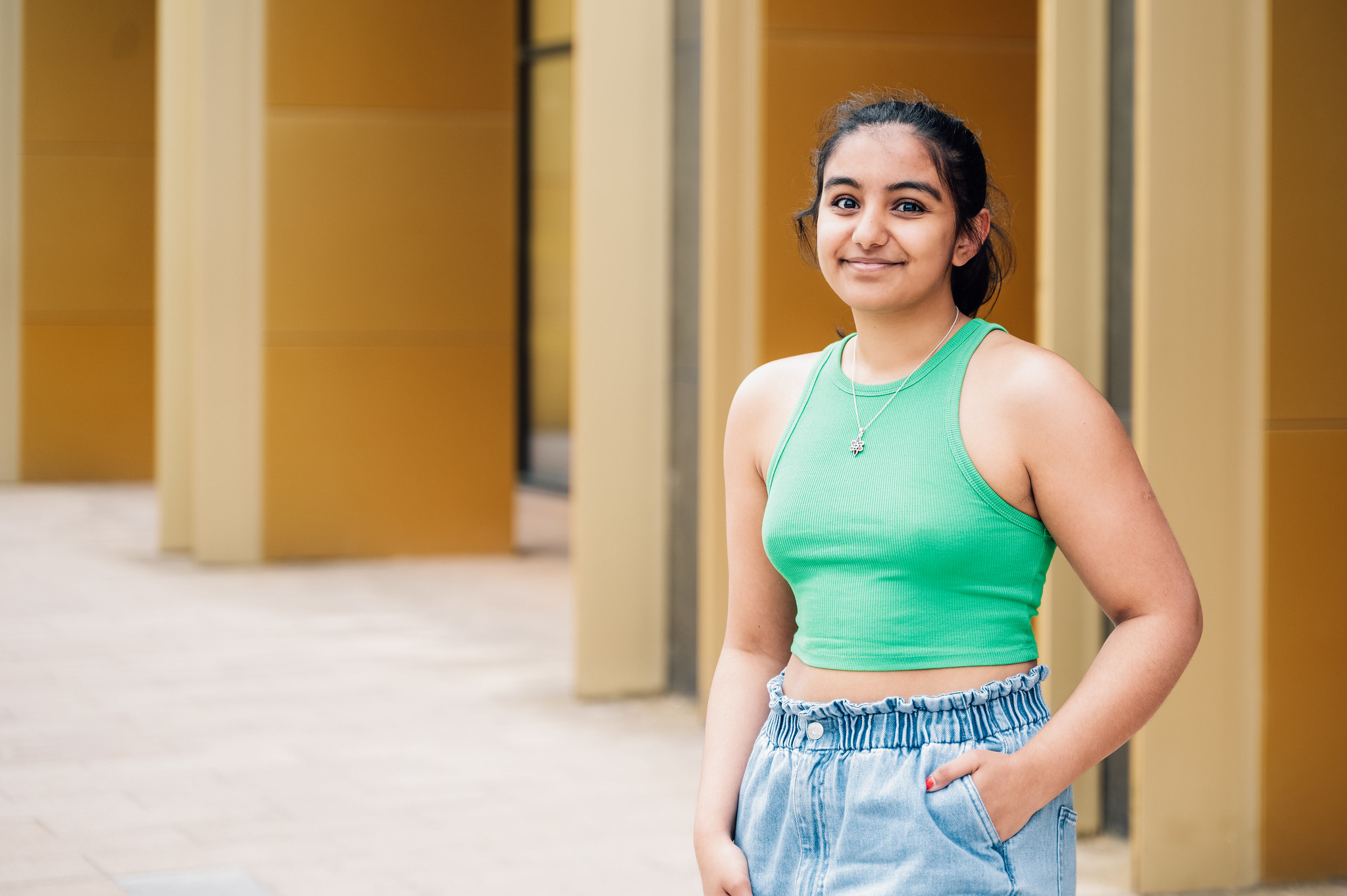 Student Rianna stands in front of the University of Birmingham Library