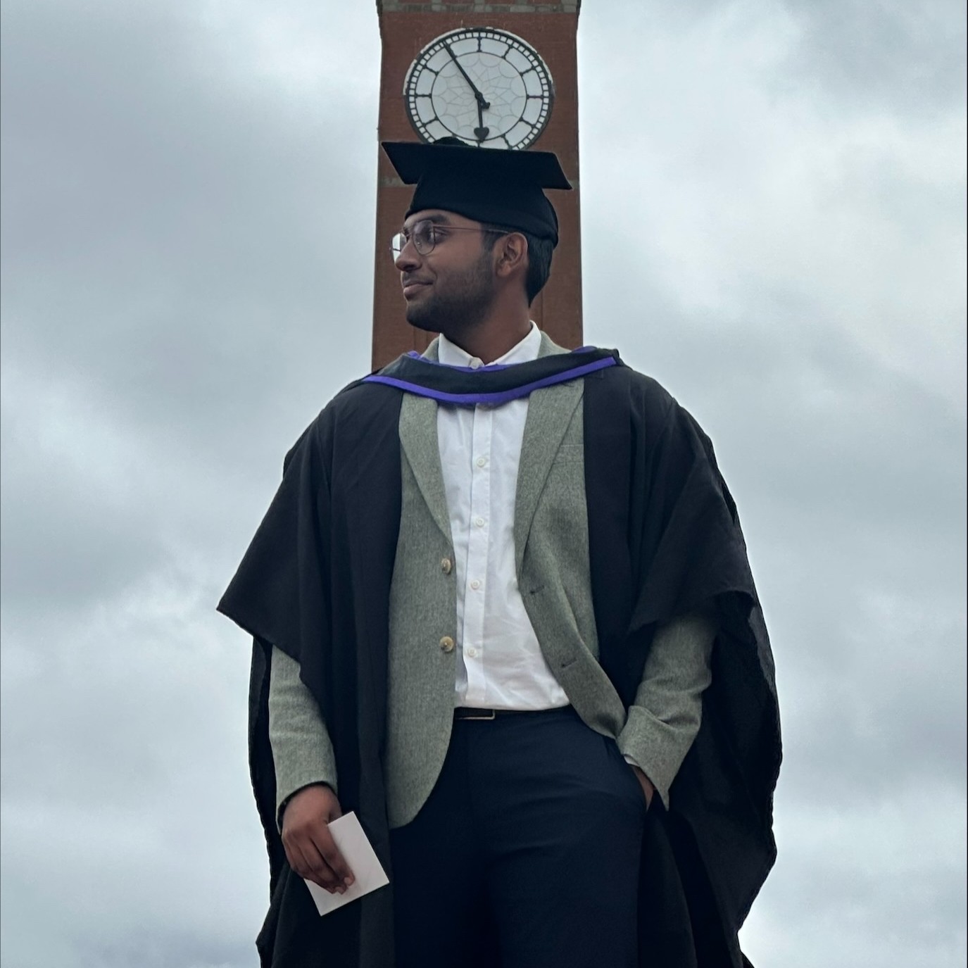 Rohit Unnithan in graduation cap and gown in front of Old Joe.