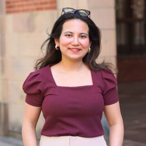 Sabina wearing a purple top smiling towards the camera