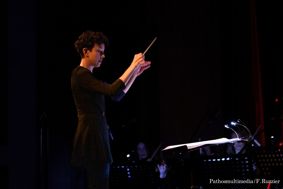 Photo of Sara Caneva conducting an orchestra.