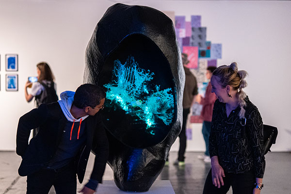 Male and female looking at a sculpture