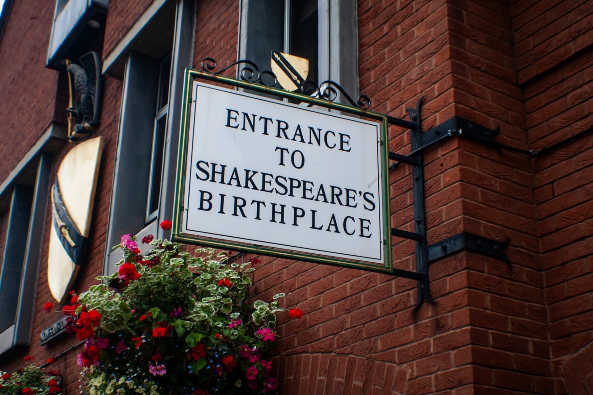 A sign on the side of a building which says Entrance to Shakespeare's birthplace