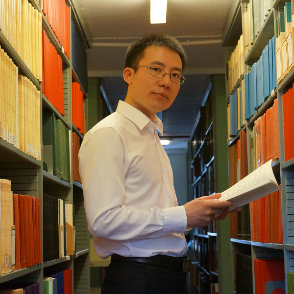 Shenshou Zhang in the library, holding a book