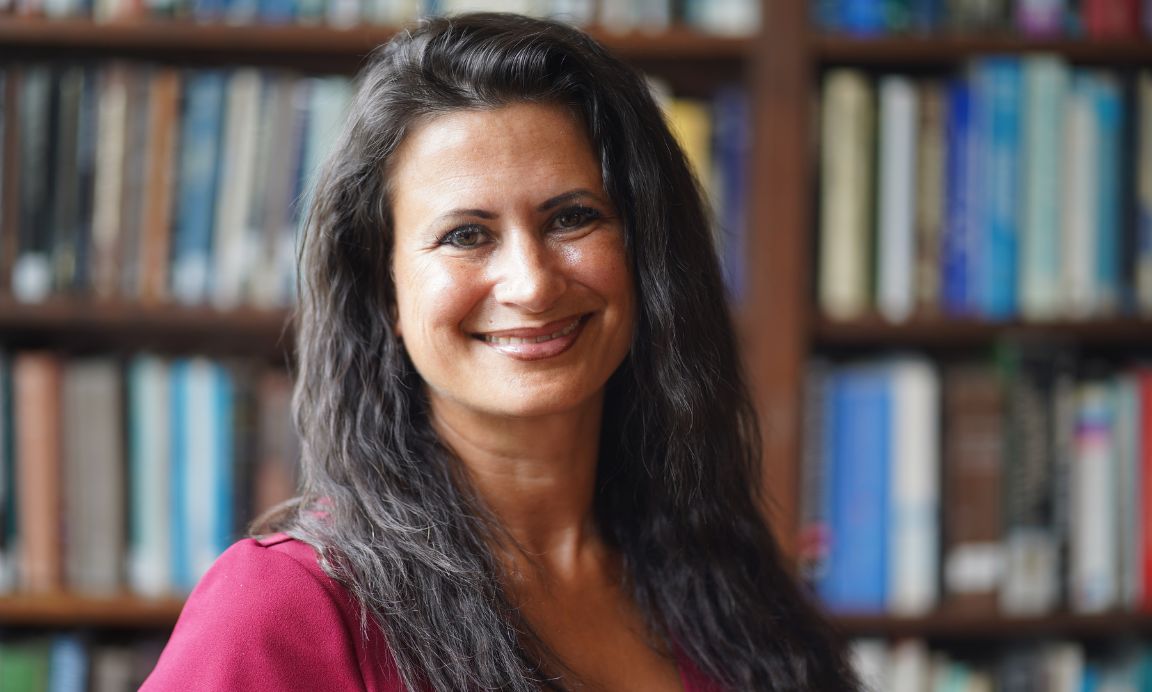 Sophie King-Hill in front of bookshelves. 