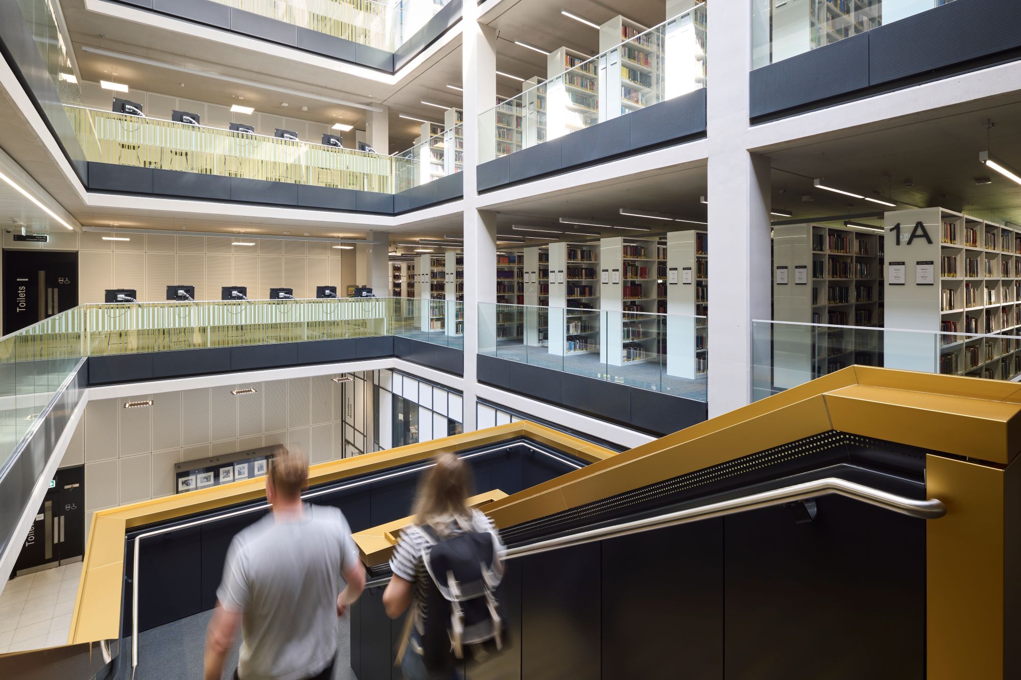Two students decend the stairs inside the University of Birmingham Library