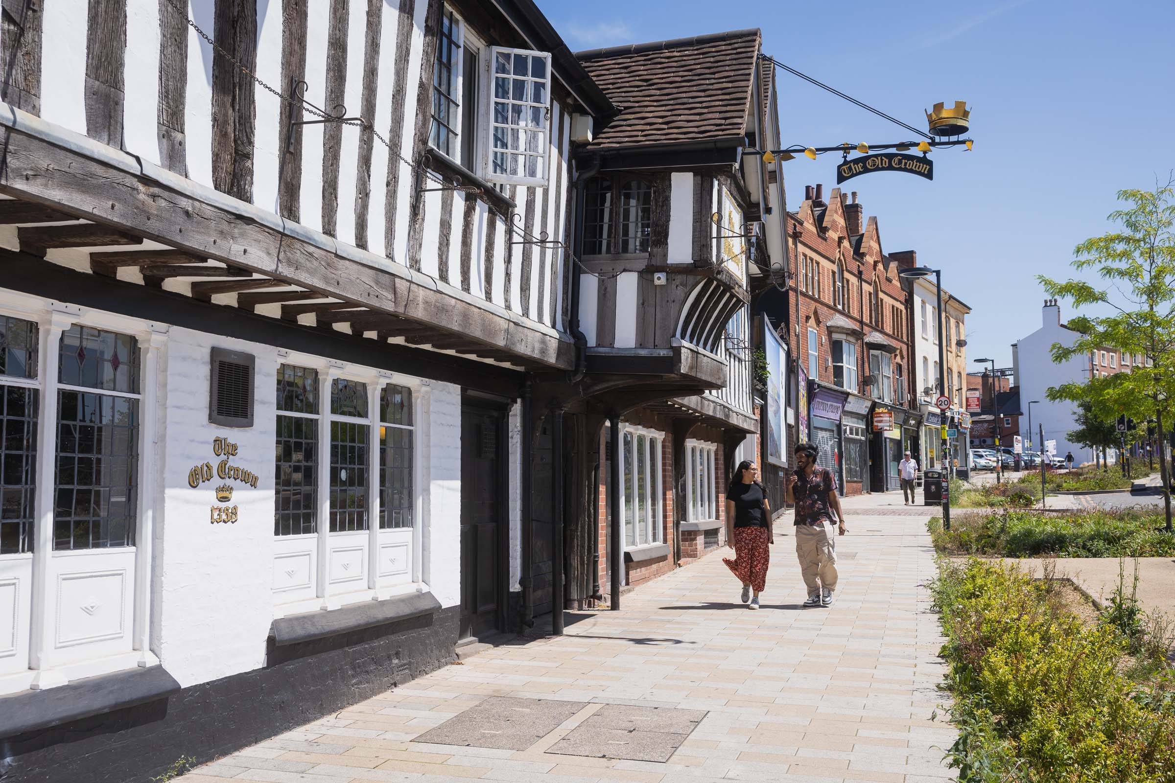 Two students walking outside The Old Crown in Digbeth on a sunny day