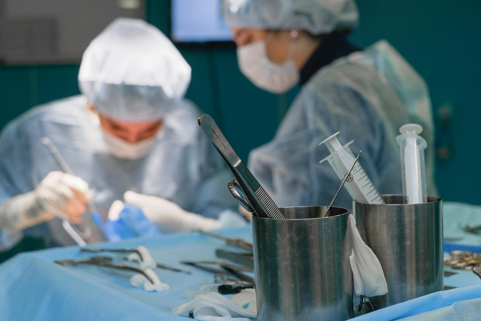 Two surgeons performing a procedure in an operating theatre.