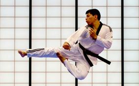 Taekwondo athlete demonstrating a flying side kick