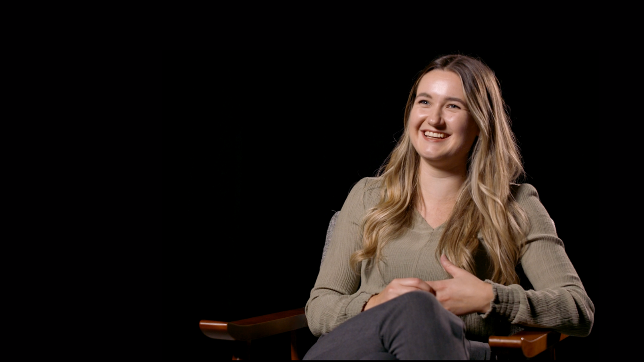 Tamsin Durrant sat on chair with black background 