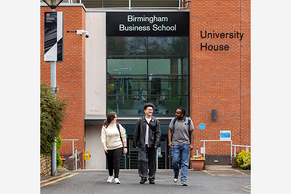 Three students walking outside of the Birmingham Business School