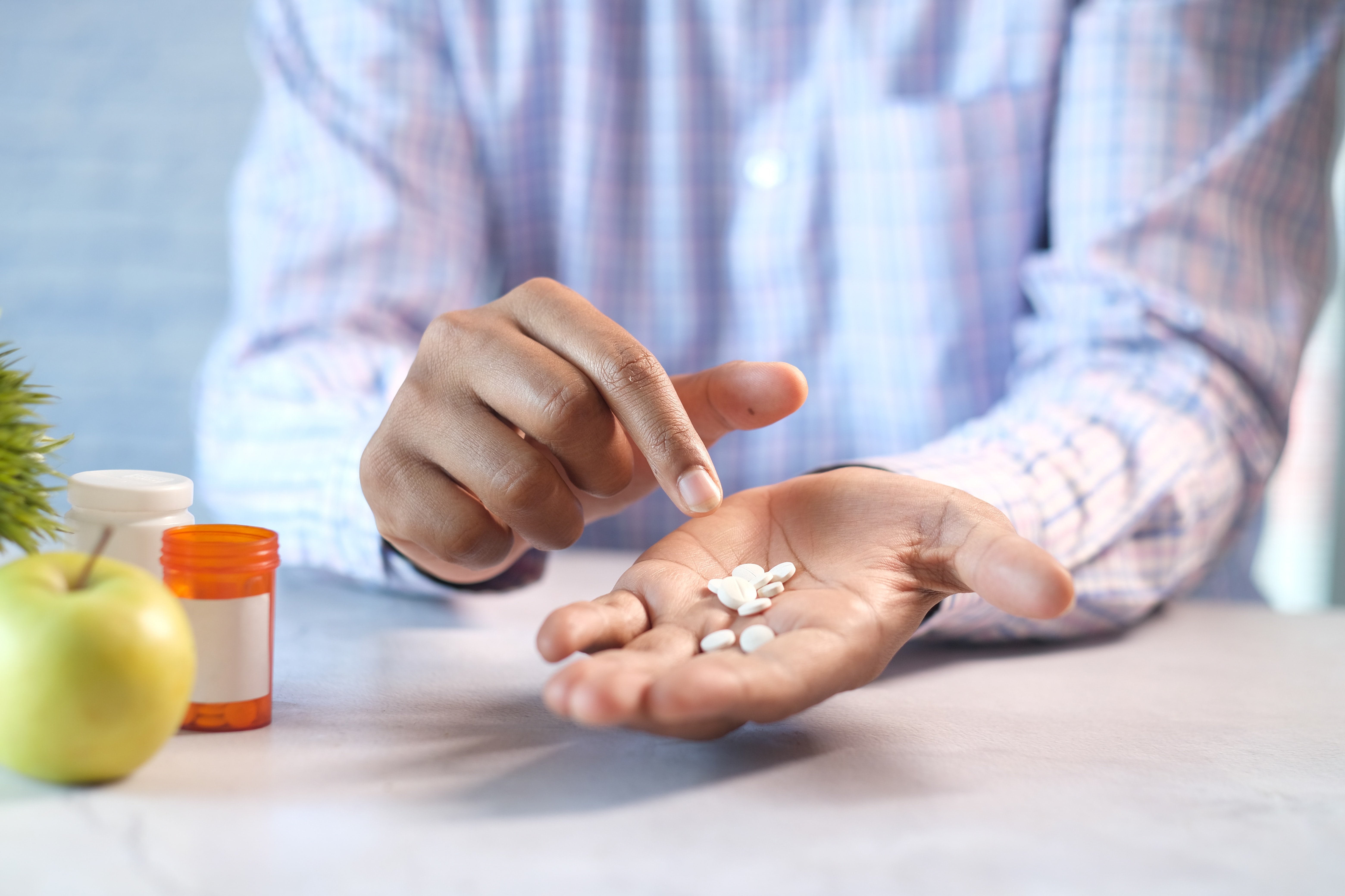 Man holding several pills in his hand