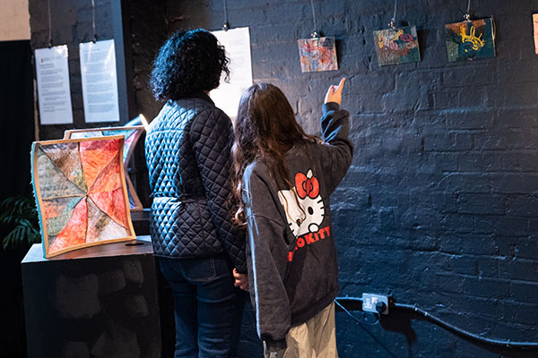Two attendees looking at the artwork in the gallery
