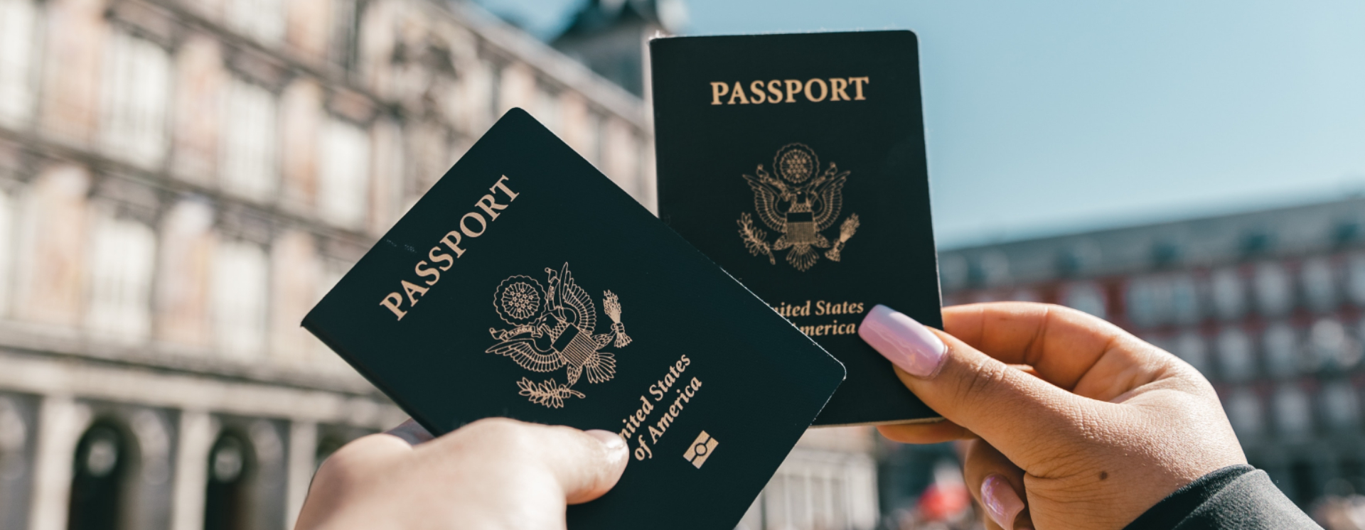 Two hands holding up two passports