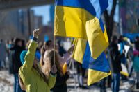 Ukraine war protesters holding Ukraine flags