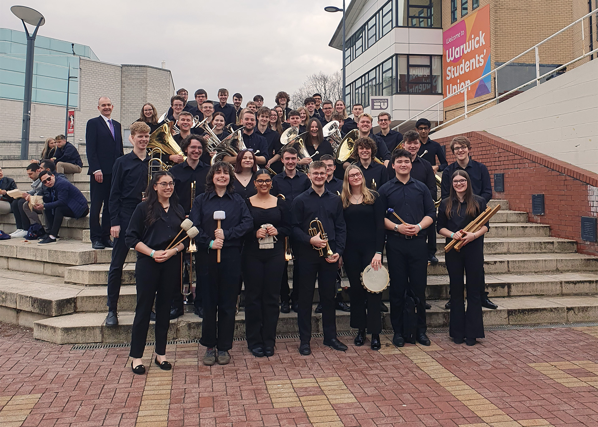 Uni Brass standing on an outdoor staircase outside Warwick Students Union