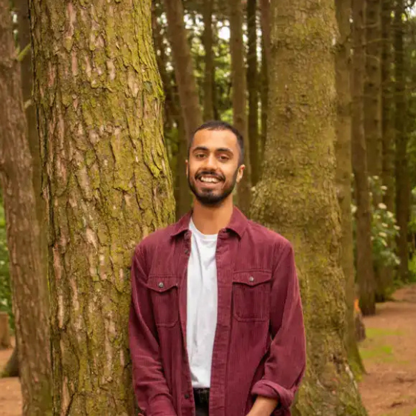 Eesa Kasujee standing in front of a tree