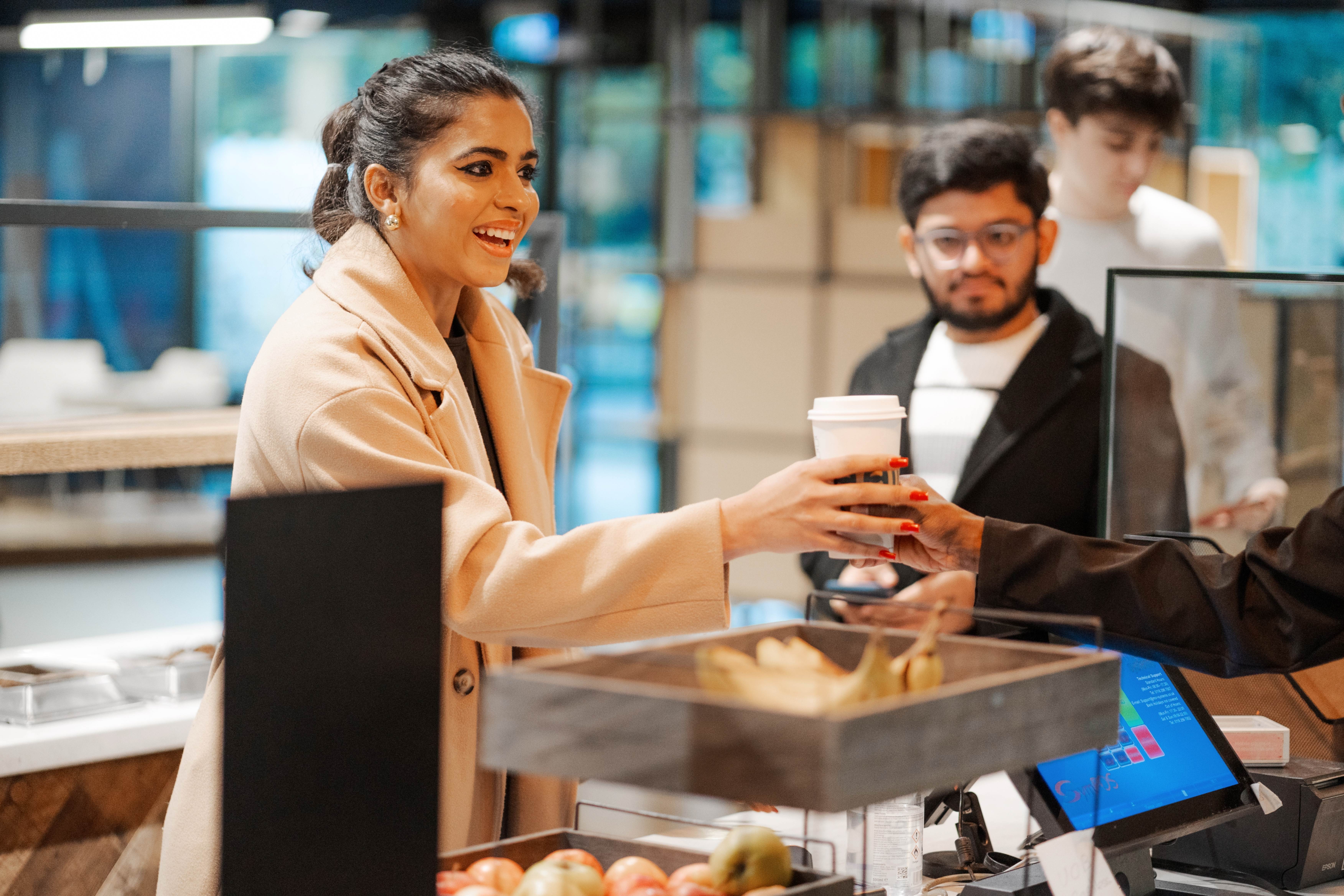 A woman receiving a cup of coffee in a restaurant