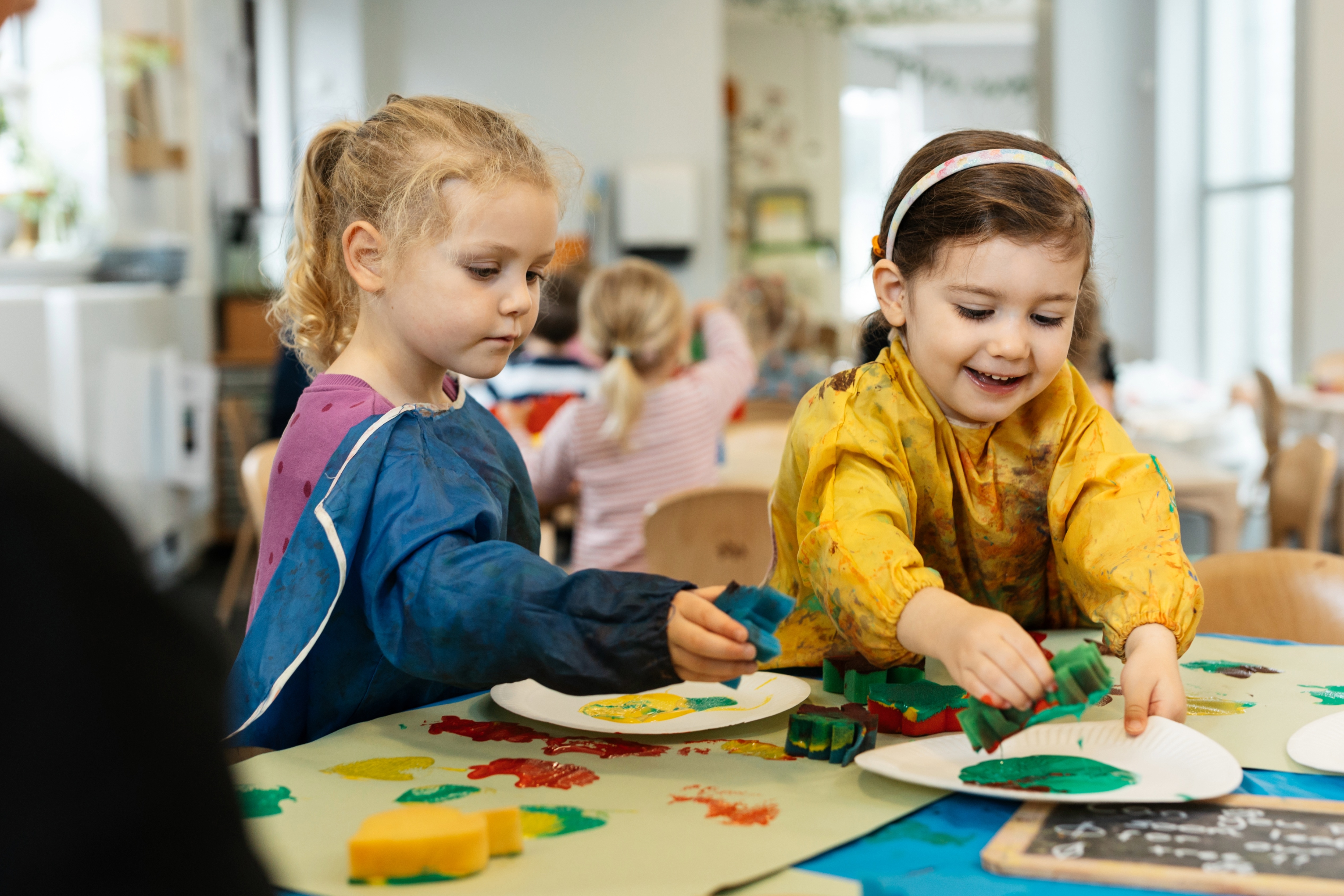 Two young girls painting together