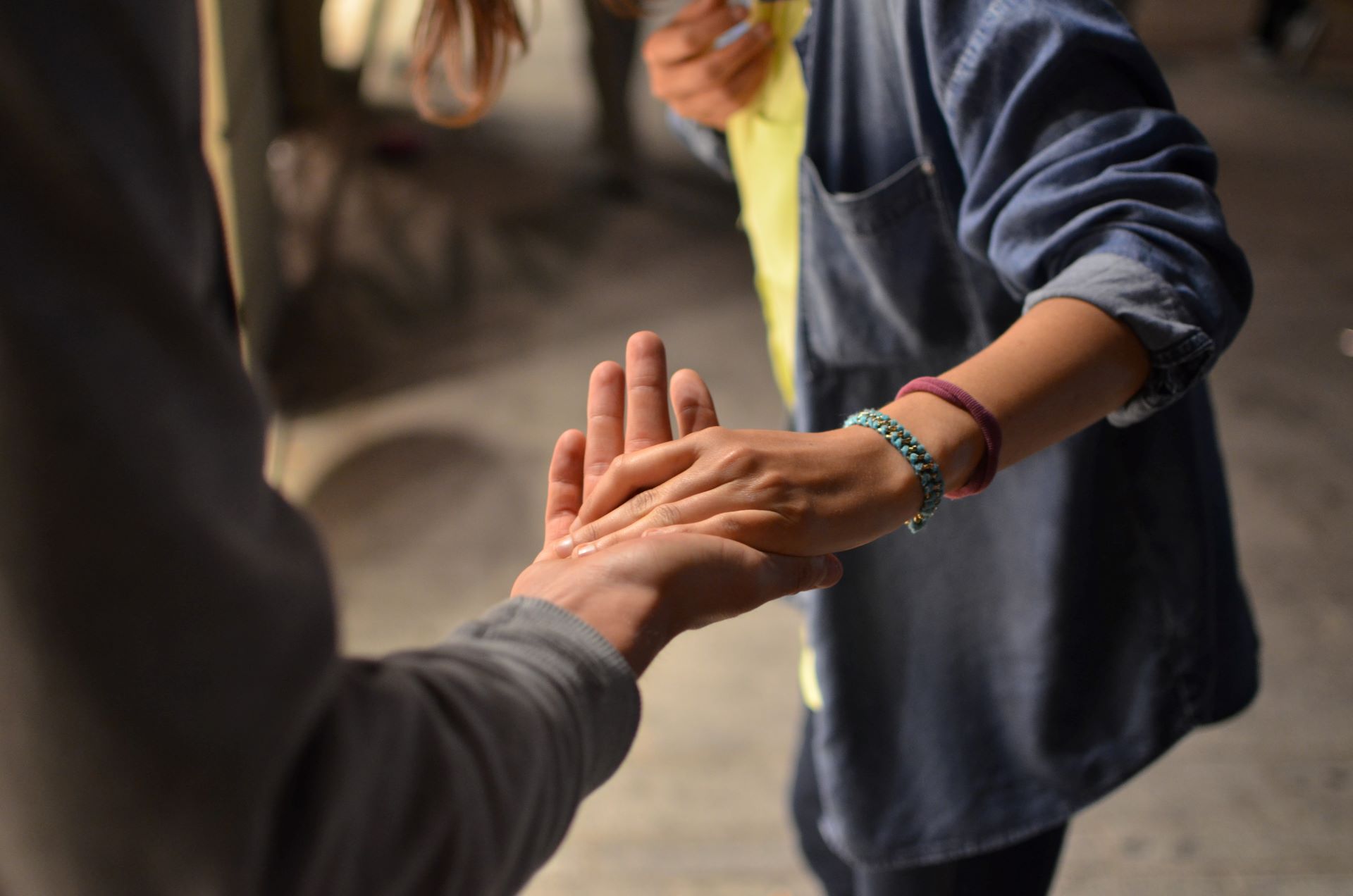 two people grasping each others hands in a street