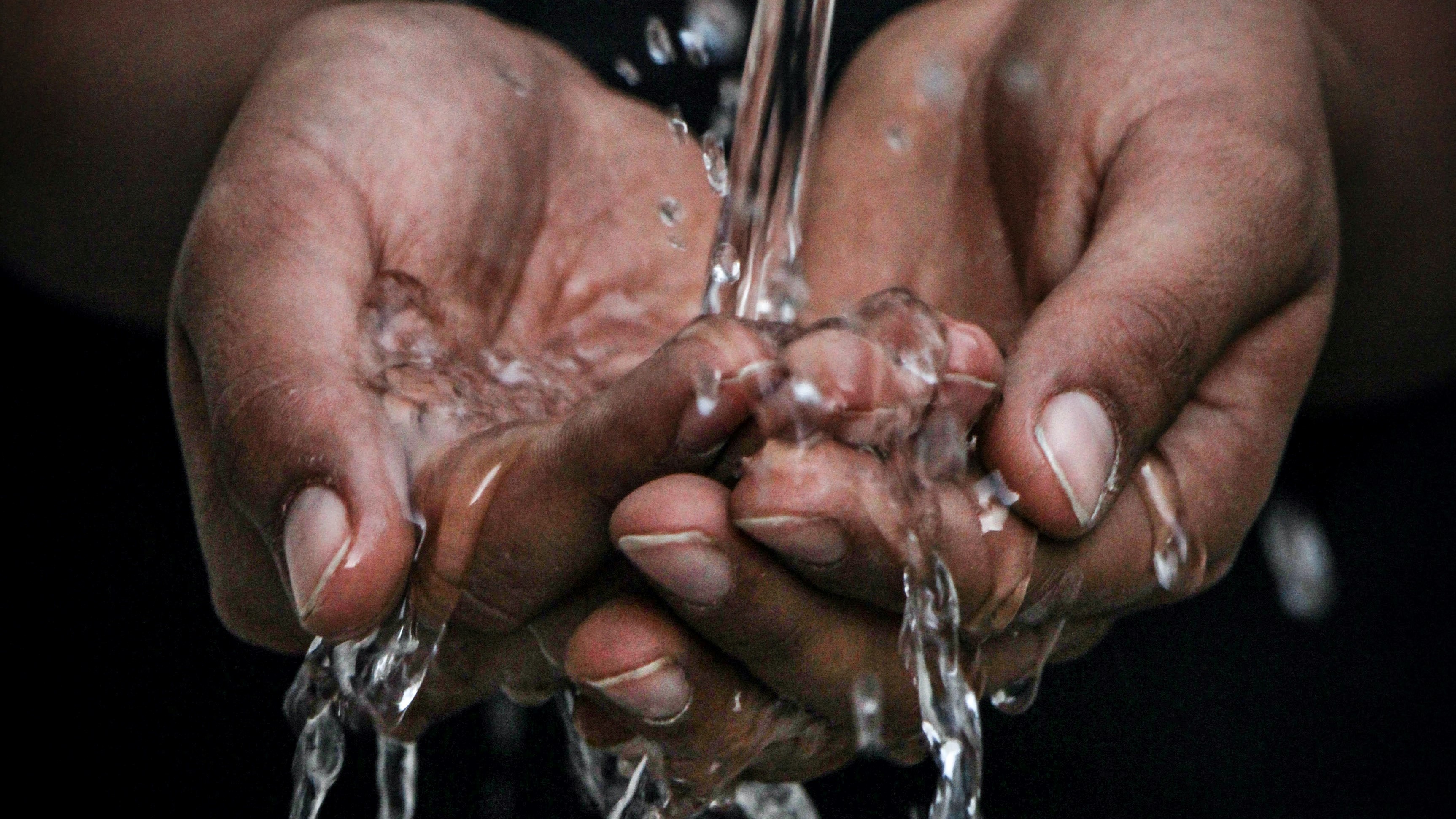Cupped hands under running water
