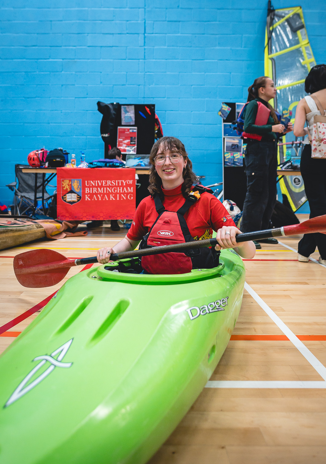 A student sat in a kayak in a sports hall