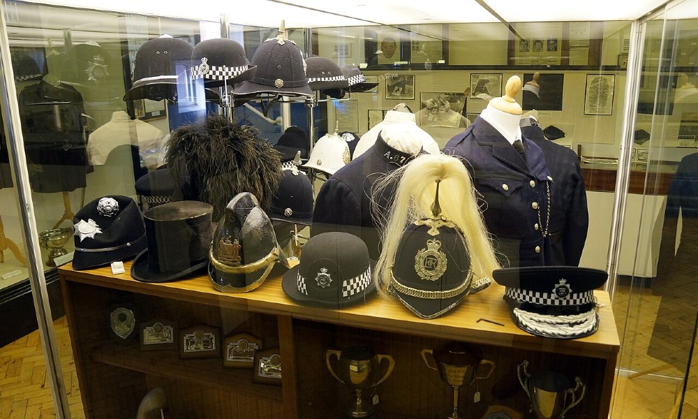 A cabinet with a range of historical police helmets