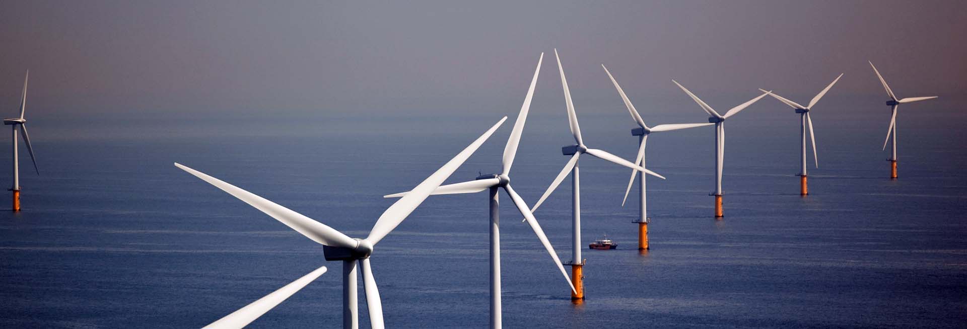 A row of wind turbines mounted in the ocean