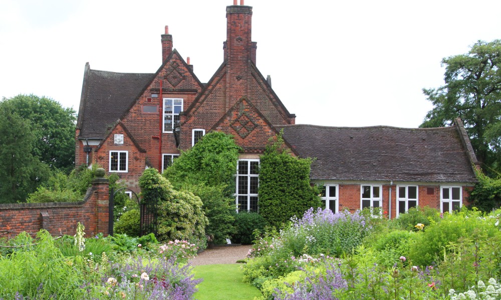 An arts and crafts style house set in gardens