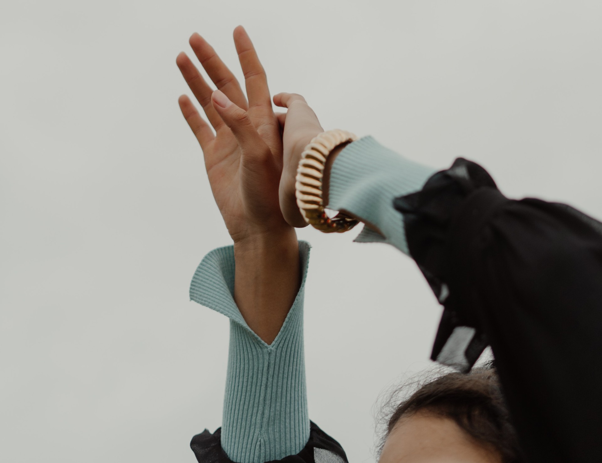 Woman with hands raised above her head