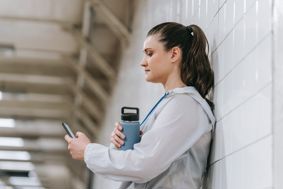 A woman wearing sporting clothes looking at a smartphone