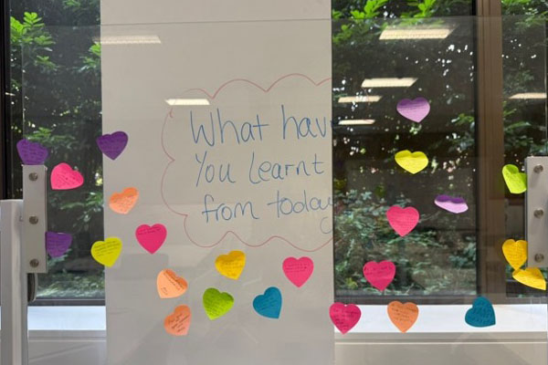 Post-it notes by a board that says 'What have you learnt from today?'