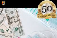Paper money lies next to a face mask