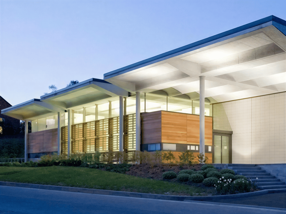 Exterior of HWB-NMR building at dusk with lights visible from within the building.