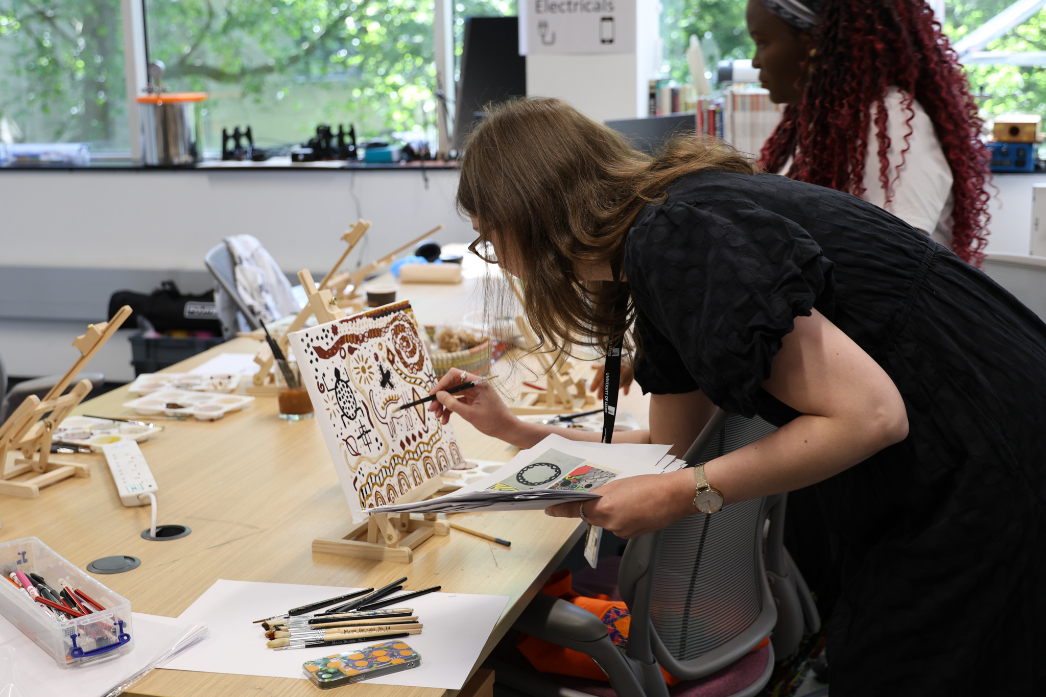 A woman paints on a canvas within an art workshop