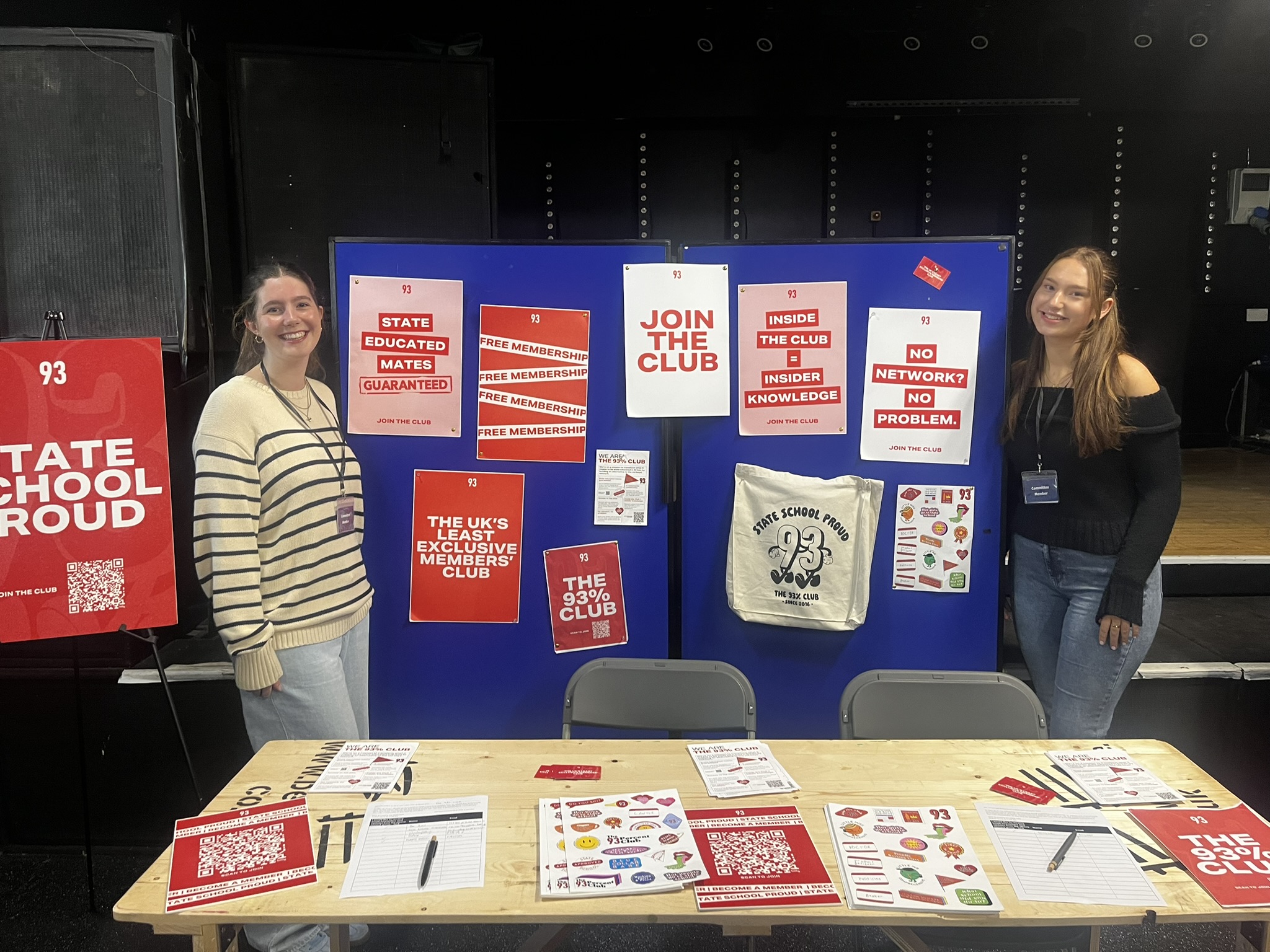 Grace promoting her society with some posters at an event