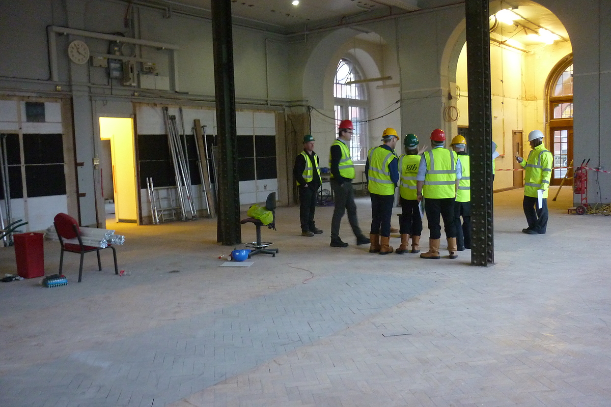 A group of workers stand in the currently vacant interior of the Lapworth Museum of Geology.