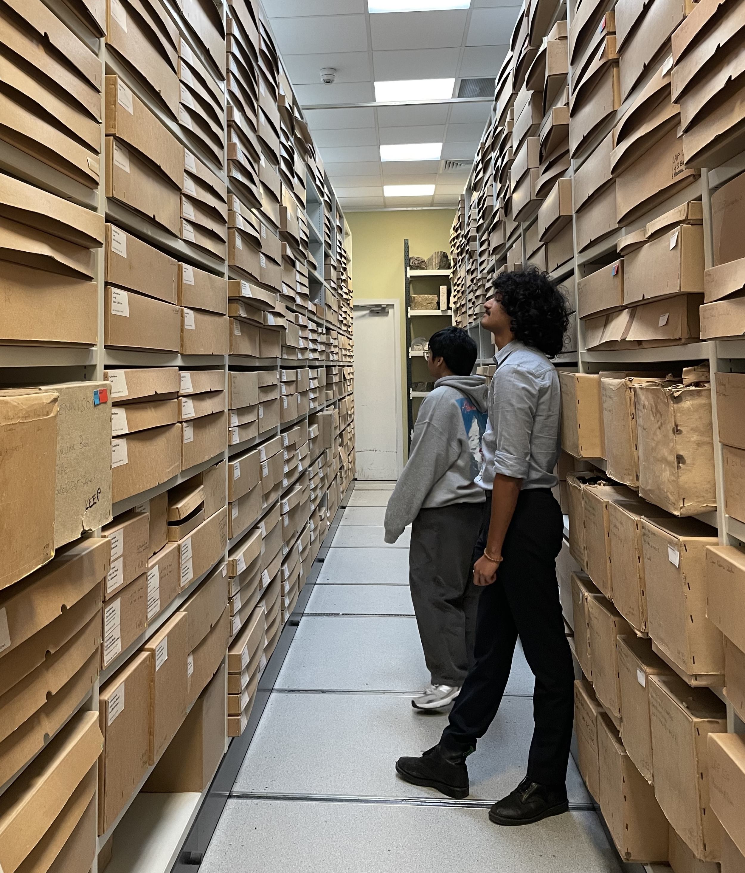 Two students stand in the Museum stores observing the vast amount of boxed material.