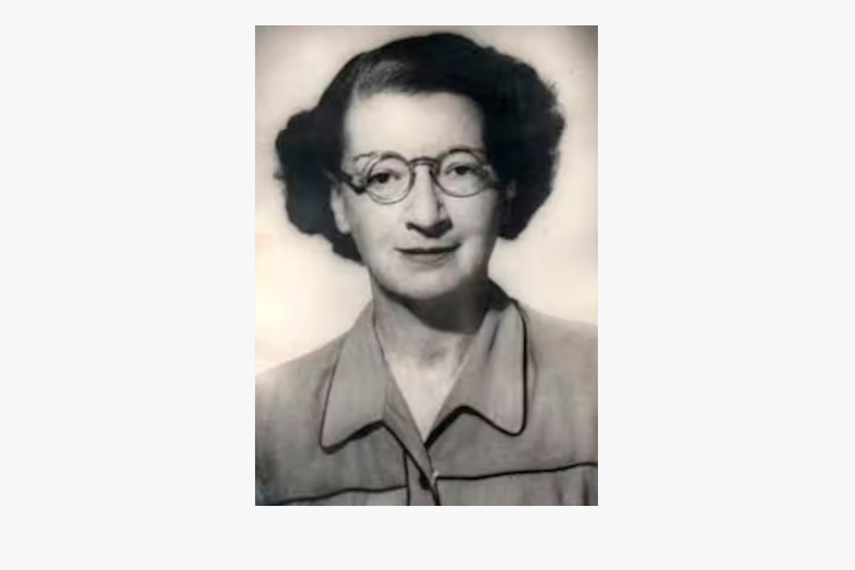 Tilly Edinger sits in a black and white portrait wearing rounded glasses.