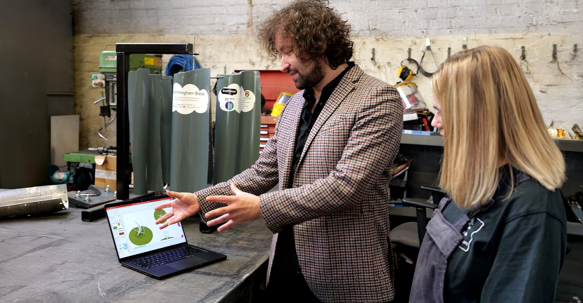 Leonard Nicusan shows a wind turbine design to precision metal fabricators KwikFab on a laptop