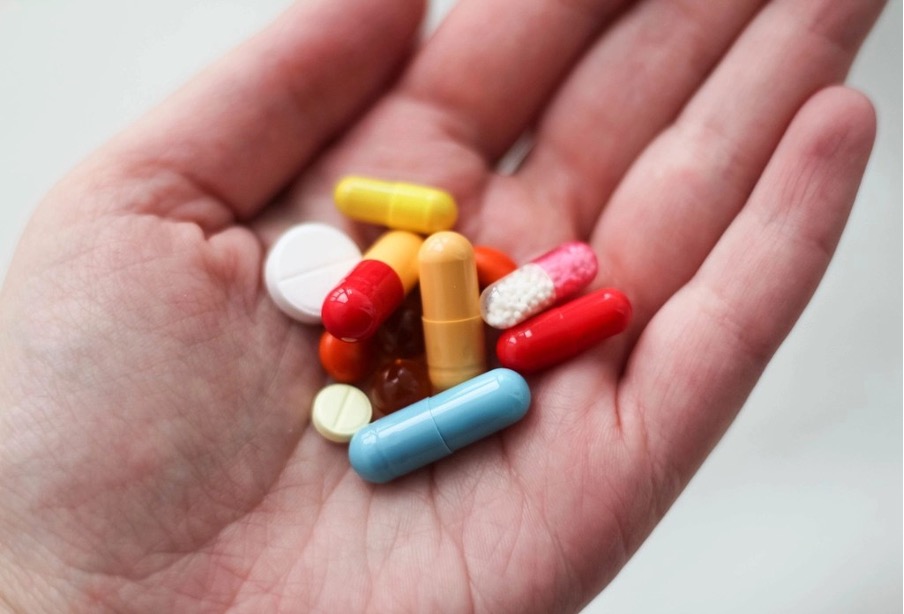 An open hand holding different tablets.