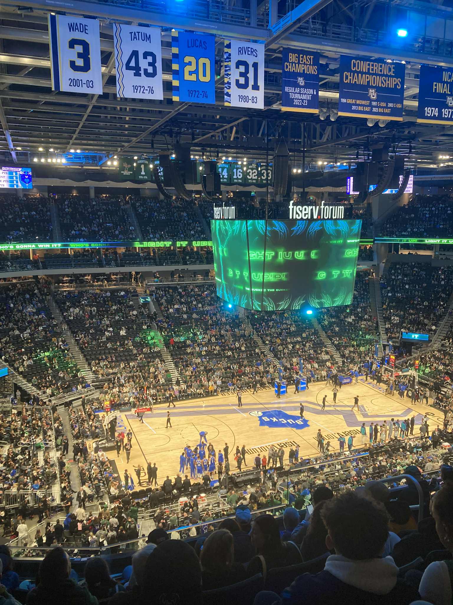 View from a seat at a basketball game in a big stadium.
