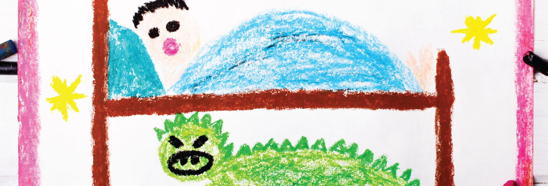 Crayon drawing of a green monster hiding under a child's bed.