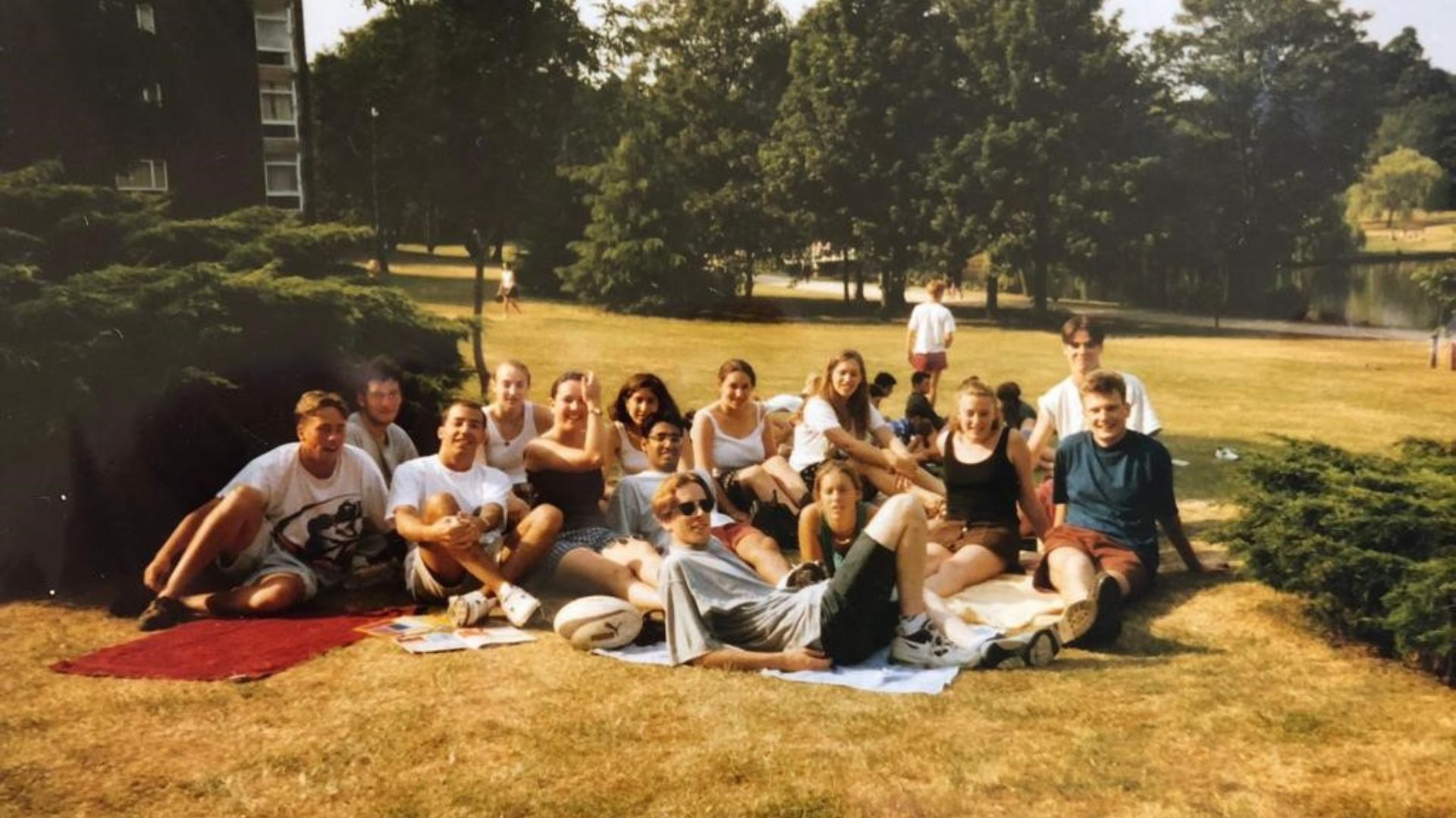 A group of students in the 1990s sitting on picnic blankets in a park