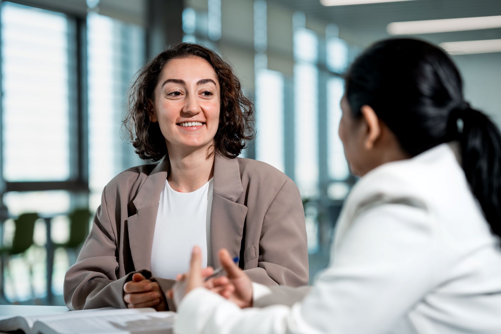 A young student in her mid twenties in conversation with an academic