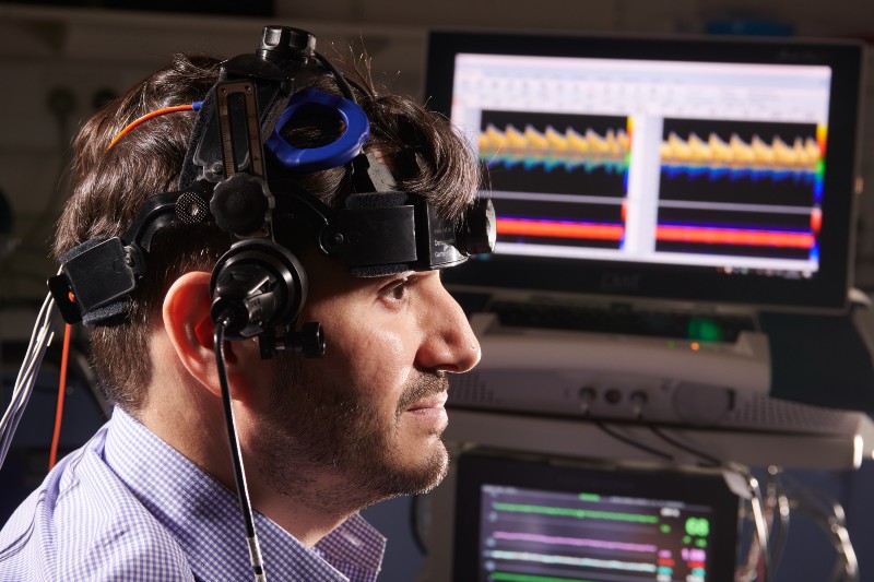 Man sitting with brain scanning equipment