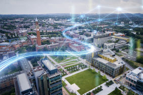 Aerial shot of the University of Birmingham's Edgbaston campus with overlaid glowing blue swooshes of connectivity